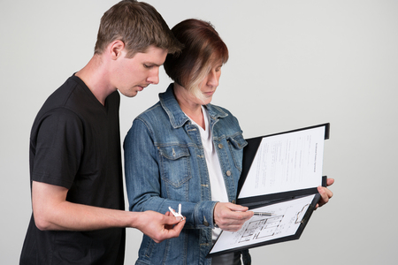 A man and woman are looking at a document.