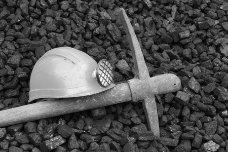 A black and white photo of a helmet and a shovel.